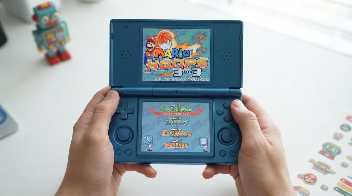 Anbernic RG DS hai màn hình trong tay nhìn từ trên xuống, màn trên chạy game DS màn dưới hiện menu